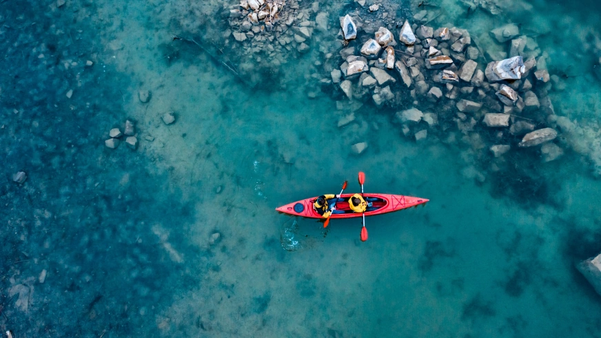 two athletic man floats red boat river