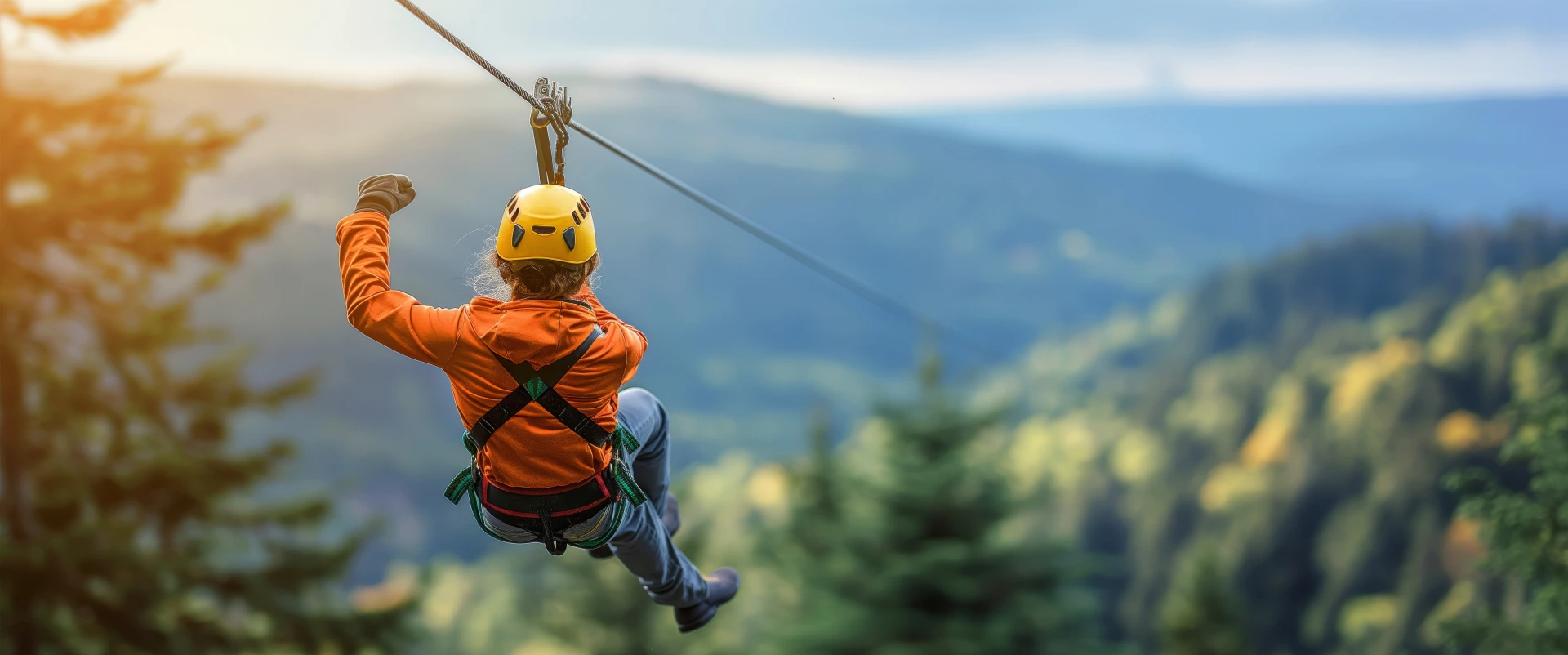 adventurer zipline ride through lush forest with beautiful mountain view cloudy sky sunset