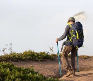 back view elderly man hiking summer day sportsman with backpack going uphill leisure sport concept 1