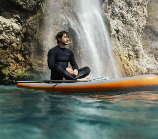 full shot young man sitting surfboard