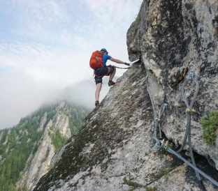 stunning shot young man climbing up cliff cold foggy day 3