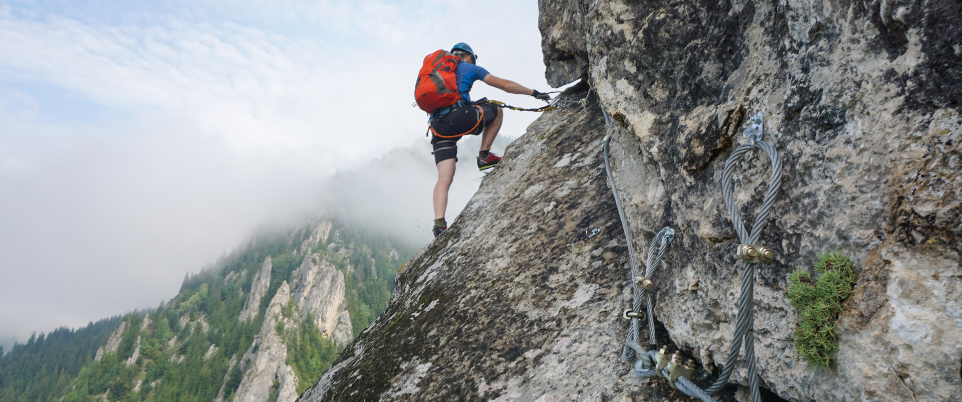 stunning shot young man climbing up cliff cold foggy day _4_