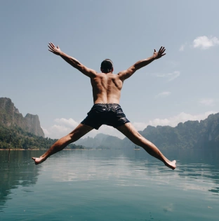 man jumping with joy by lake 11
